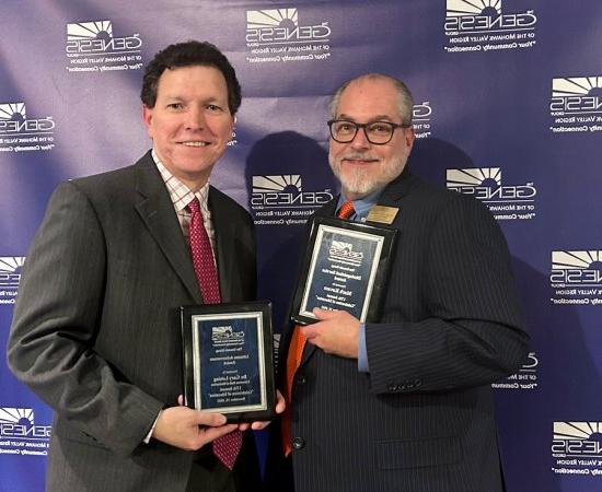 马克Kovacs and Gary Leising hold up plaques at the Genesis Group's Celebration of Education event in November 2023.